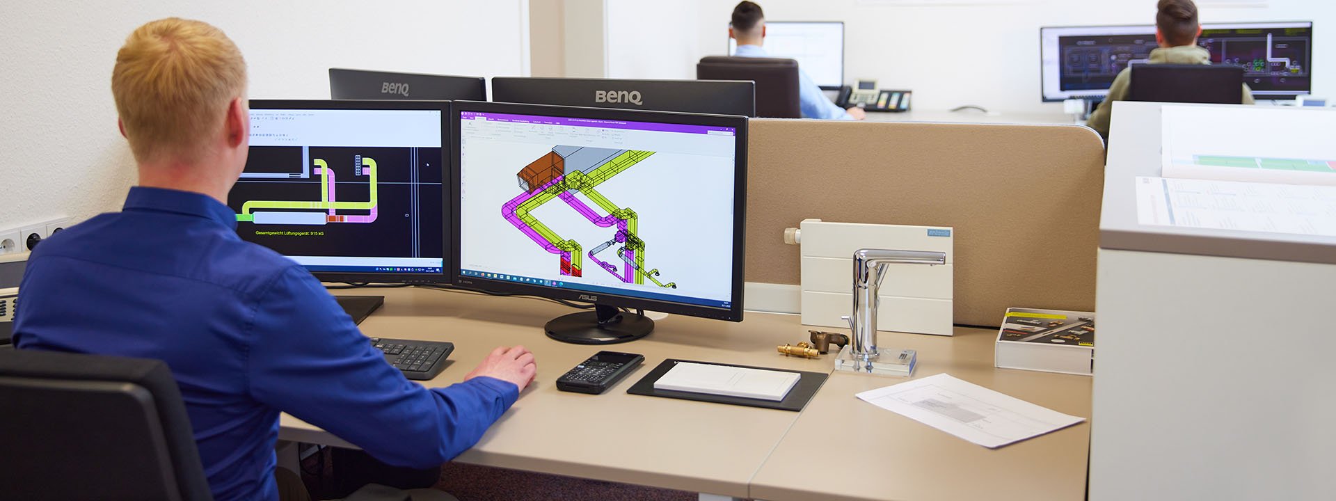 Mitarbeiter bei der CAD-Planung von Gebäudetechnik an zwei Monitoren