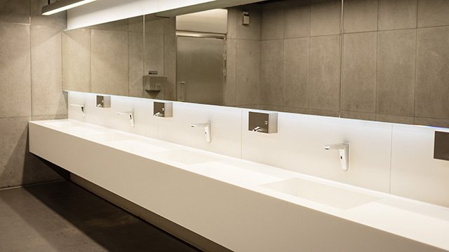 Moderne Waschtischanlage mit berührungslosen Armaturen in einem öffentlichen Sanitärraum
