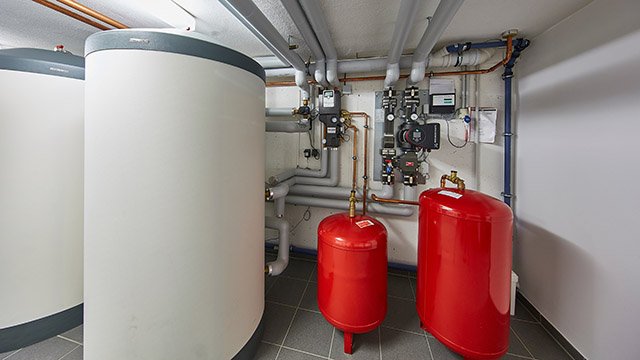 Heizungsraum mit modernen Pufferspeichern, Ausdehnungsgefäßen und Rohrsystem