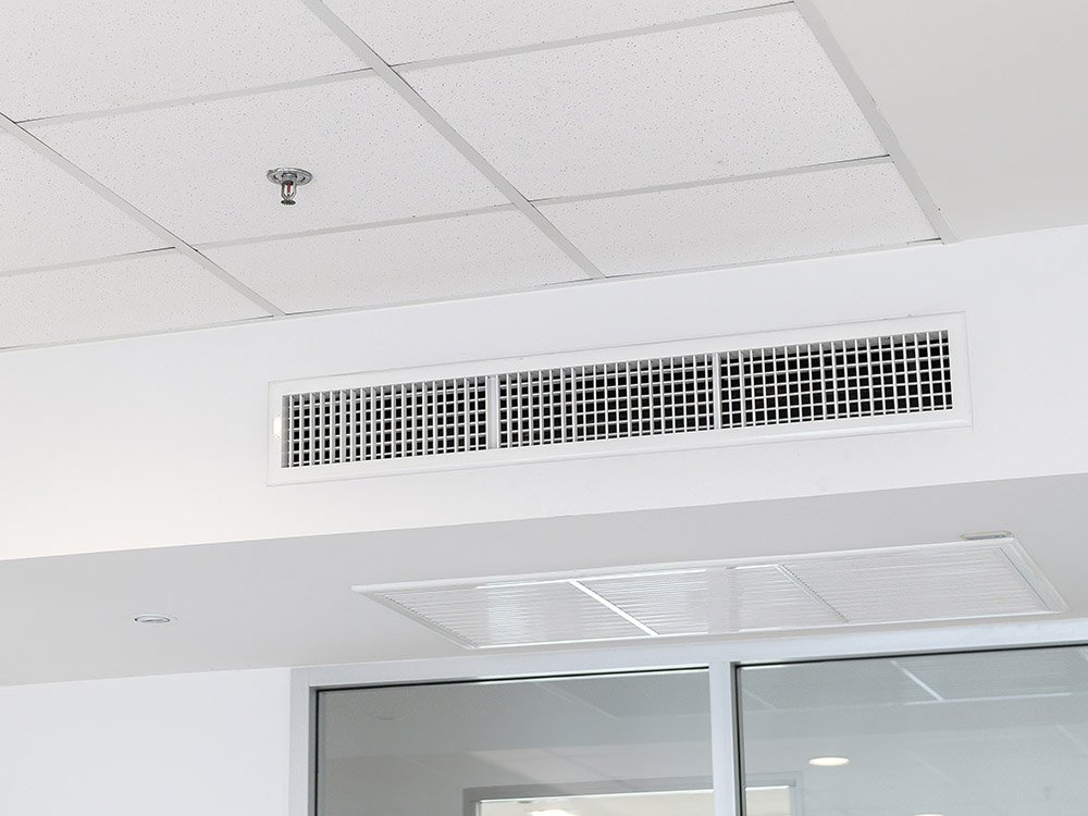 Deckenlüftung mit Luftauslässen und Brandschutzsprinkler in einem Bürogebäude